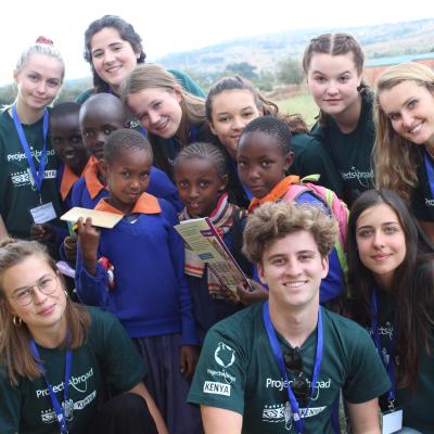 Healthcare volunteers take a group photo with students during a medical outreach in Kenya